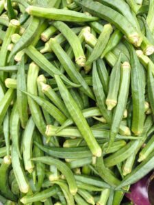 A vibrant display of fresh green okra pods piled together, perfect for culinary uses.